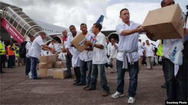 Miembros de la brigada médica cubana enviada a Liberia descargan materiales a su llegada a Monrovia.