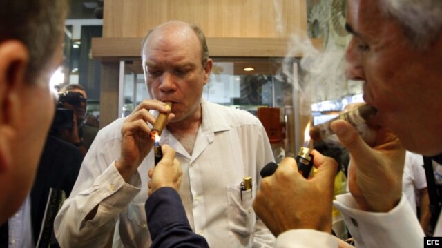 El ministro cubano de Inversión Extranjera, Rodrigo Malmierca (c),  enciende un puro durante la inauguración de la feria comercial del XIV Festival del Habano, en La Habana. 