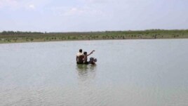 En esta foto del 2004 varias personas recojen agua en una de las presas que abastecen a la oriental provincia de Holguín.