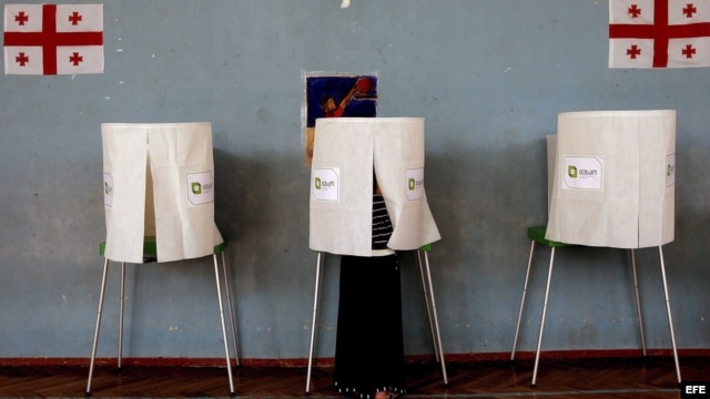 Una mujer prepara una cabina en un colegio electoral en Sartichala, a unos 30 kilómetros de Tbilisi, Georgia. 