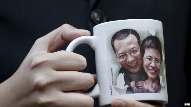 Un activista pro democrático muestra un retrato del disidente chino Liu Xiaobo y de su esposa Liu Xia.    