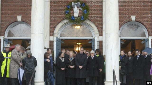 El gobernador de Connecticut, Dannel Malloy (c), escucha los 26 repiques de una campana, en recuerdo a las víctimas de los tiroteos en la escuela elemental Sandy Hook, en el Ayuntamiento de Newtown, Connecticut, EE.UU.