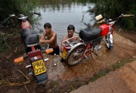 Un grupo de jóvenes lavan sus motocicletas en el Río Guanímar.