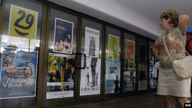 Una mujer observa varios carteles de las películas que exhibe un cine en La Habana (Cuba).