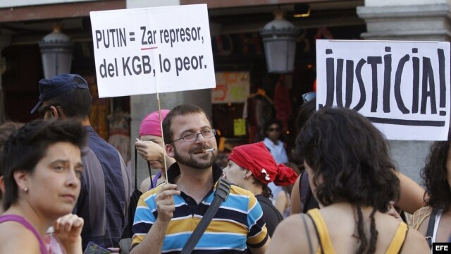 Participantes en la concentración en apoyo al grupo punk Pussy Riot, acusadas por cantar en una catedral ortodoxa una canción contra el presidente de Rusia, Vladimir Putin, sostiene una pancarta durante la manifestación que ha tenido lugar esta tarde en l