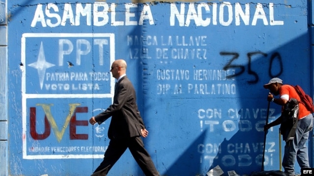 Un hombre pasa frente a un mural invitando a votar en las elecciones para elegir los diputados de la Asamblea Nacional. Foto de archivo.