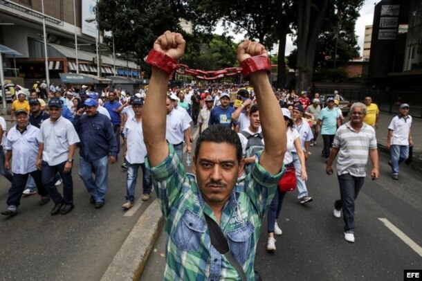 Un hombre simboliza con cadenas la prisión que es el sistema socialista hoy, jueves 1 de septiembre de 2016, en una manifestación denominada "Toma de Caracas".