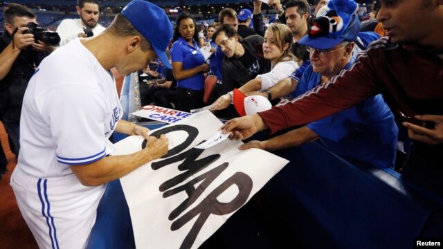 Omar Vizquel firma autógrafos tras finalizar el partido con los Mellizos de Minnesota en octubre de 2012.  