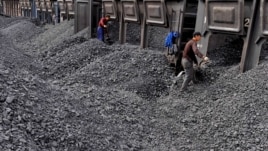 Trabajadores amontonan carbón en una estación de procesamiento de Beishan, cercano a Shanyang, China, que es mayor consumidor de carbón.