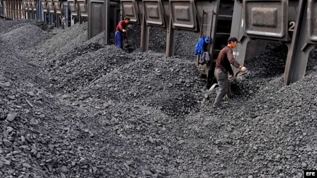 Trabajadores amontonan carbón en una estación de procesamiento de Beishan, cercano a Shanyang, China, que es mayor consumidor de carbón.
