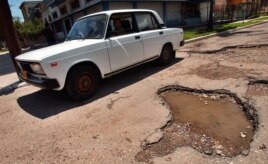 Un automóvil trata de evitar los baches de las calles de La Habana, Cuba.