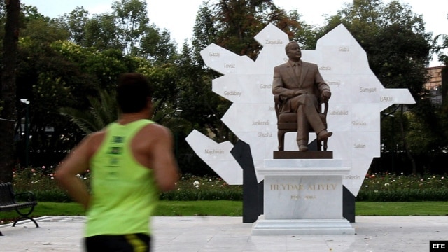 Un hombre hace deporte frente a la escultura del expresidente de Azerbaiyan Heydar Aliyev en el Paseo de la Reforma de Ciudad de México. 