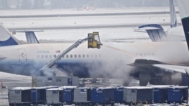 Personal limpia la nieve sobre un avión de United Airlines