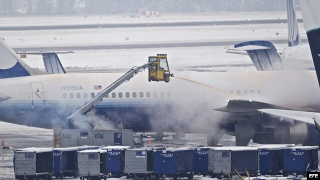  Personal limpia la nieve sobre un avión de United Airlines