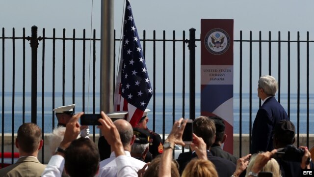 El secretario de Estado John Kerry (d) presencia el izado de la bandera estadounidense en la embajada en La Habana.
