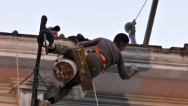 Dos hombres trabajan en la reparación de una vivienda.