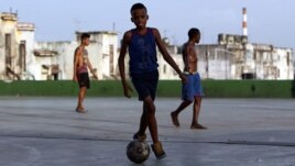 Niños jugando al fútbol en calles y plazas cubanas.