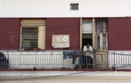 Un hombre camina junto a una casa puesta a la venta en La Habana.