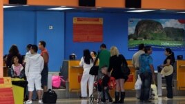  Varias personas chequean sus documentos para abordar un vuelo hacia Miami (EEUIU), en la Terminal 2 del aeropuerto José Martí de La Habana (Cuba).  