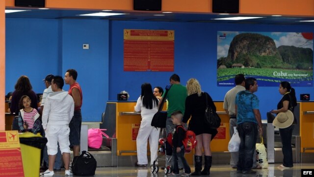  Varias personas chequean sus documentos para abordar un vuelo hacia Miami (EEUIU), en la Terminal 2 del aeropuerto José Martí de La Habana (Cuba).  