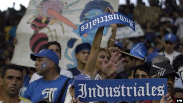 Varios aficionados del equipo de Industriales animan a su equipo.