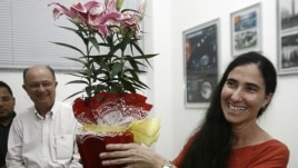 Yoani Sánchez (d), autora del blog "Generación Y", sonríe con un regalo recibido durante su primera jornada de visita a Brasil en Feira de Santana.