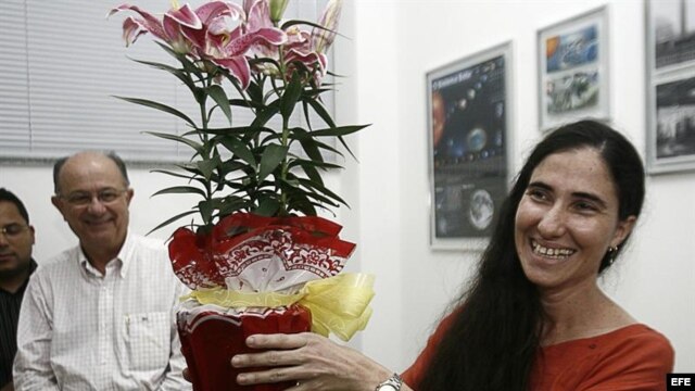 Yoani Sánchez (d), autora del blog "Generación Y", sonríe con un regalo recibido durante su primera jornada de visita a Brasil en Feira de Santana.