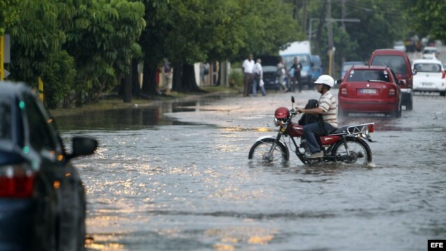 Un hombre conduce una motocicleta por una calle inundada el miércoles en La Habana.