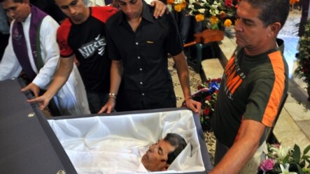 HAB100. LA HABANA (CUBA), 23/07/2012.- Reinaldo Payá (c), hijo del fallecido opositor Oswaldo Payá, observa los restos de su padre hoy, lunes 23 de julio de 2012, en una iglesia de La Habana (Cuba). Unas 400 personas recibieron hoy los restos mortales de 