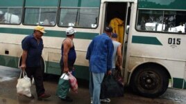 Varias personas suben a un ómnibus Girón.