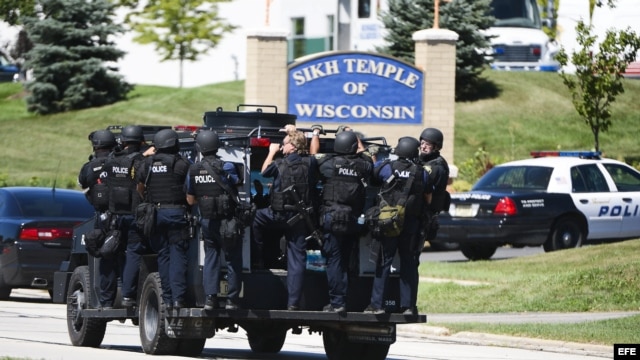 Un vehículo de la Policía transporta a varios oficiales, tras un tiroteo en un templo de la comunidad sij en Oak Creek, estado de Wisconsin, EE.UU. 