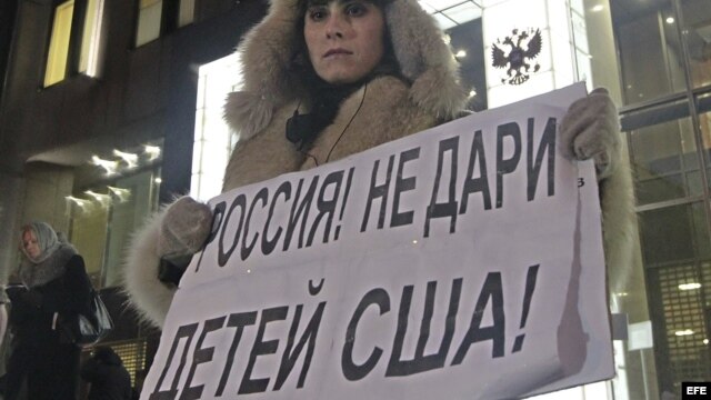 Una mujer protesta en contra de la prohibición de adopción de huérfanos rusos a ciudadanos americanos a las puertas del Consejo de la Federación en Moscú (Rusia). 