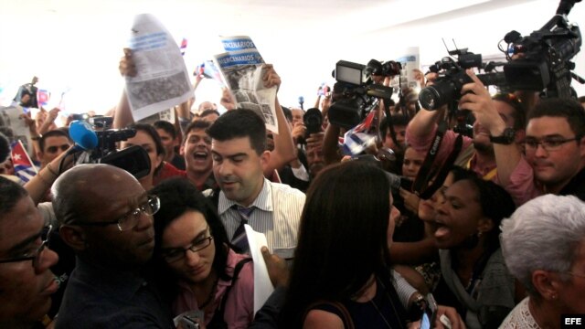 Los opositores cubanos Manuel Cuesta Morúa (i) y Lilianne Ruiz (c) son hostigados por miembros de la delegación oficialista cubana a la entrada del 