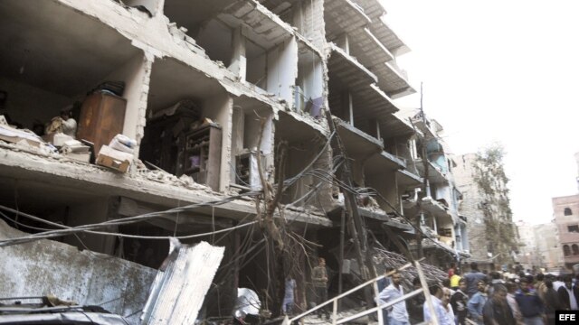 Fotografía cedida por la agencia de noticias SANA que muestra a unos ciudadanos sirios en el lugar donde se registró la explosión de un coche bomba en el barrio de Def al Shuk en Damasco, Siria. 