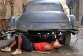 Un hombre trabaja en la reparación de un auto.