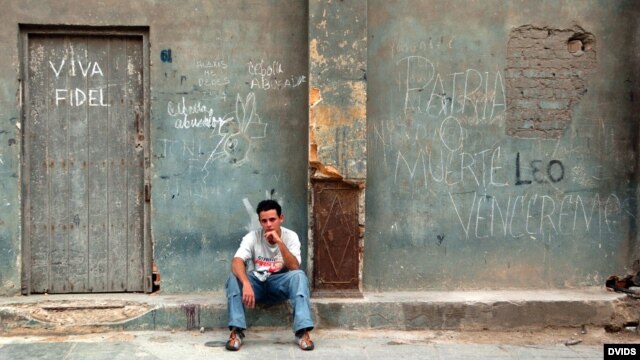 Un jombre permanece sentado junto a un cartel alusivo al presidente cubano Fidel Castro, en La Habana. 