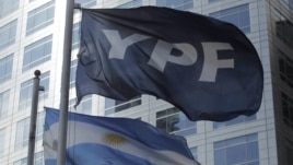 Detalle de las banderas de Argentina y de la petrolera YPF frente al edificio donde funcionan las oficinas centrales de la empresa en Buenos Aires. 