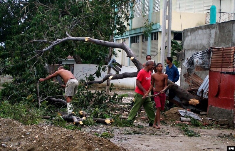  Varias personas trabajan talando árboles derribados por el paso del huracán Sandy por el poblado de Caimanera, en la provincia de Guantánamo (Cuba). 