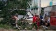 Varias personas talan árboles derribados por el huracán Sandy en el poblado de Caimanera, en la provincia de Guantánamo (Cuba). 