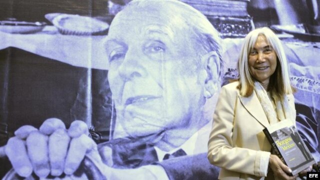 La viuda del escritor Jorge Luis Borges, María Kodama, posa con la imagen del autor al fondo.