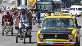 Bicitaxis y taxis en las calles de La Habana.