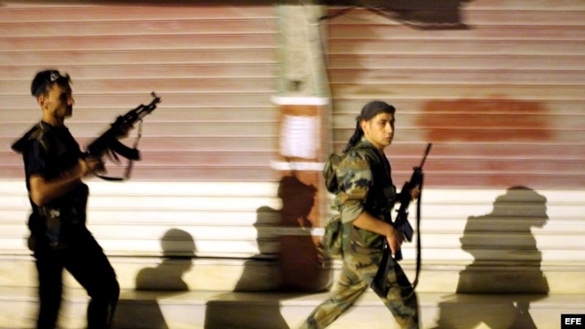Rebeldes sirios patrullan por las calles de Alepo, Siria. 