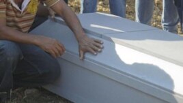 Una persona junto al ataúd de un familiar