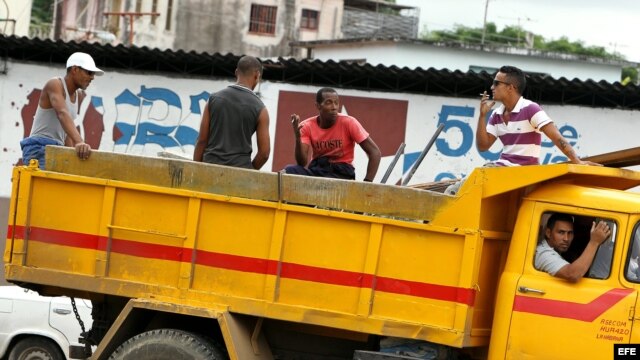Varios obreros viajan en la parte trasera de un camión en La Habana (Cuba).