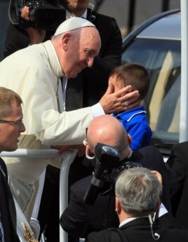 El papa Francisco saluda a un niño a su llegada a la Catedral en Santiago de Cuba.