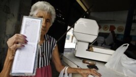 Una anciana muestra su libreta de racionamiento.