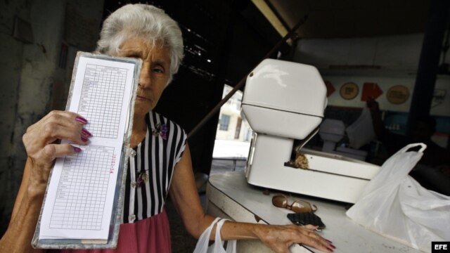 Una anciana muestra su libreta de racionamiento.