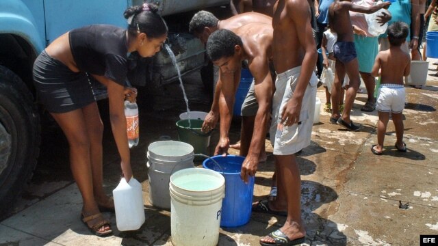 Cubanos se  abastecen de agua en pipas.