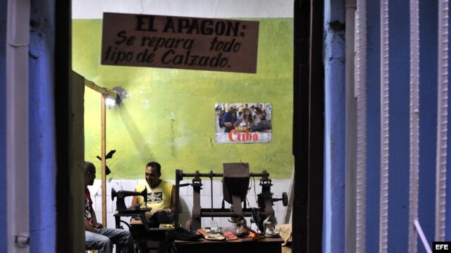 Un zapatero mantiene su taller privado abierto hasta la noche.