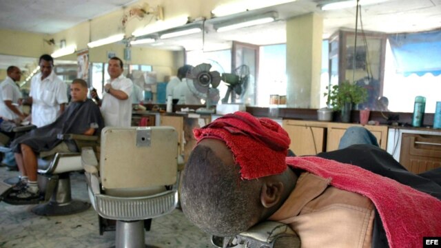 Un cliente se somete a un tratamiento de belleza en una barbería en Santiago de Cuba.